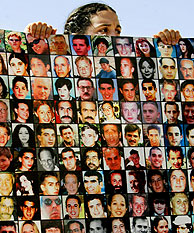 Una mujer israel muestra las fotos de algunos muertos en ataques palestinos. (Foto: AP)