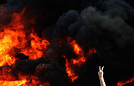 Un israel hace el smbolo de la victoria frente a una barricada en llamas en el asentamiento de Katif. (Foto: REUTERS)