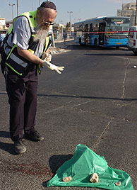 Un forense israel tapa la cabeza del suicida palestino. (Foto: AFP)