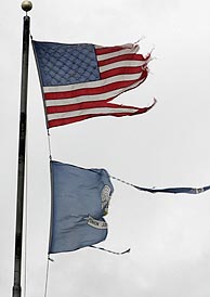 Las banderas de EEUU y del Estado de Luisiana, azotadas por los vientos del 'Rita'. (Foto: AFP)