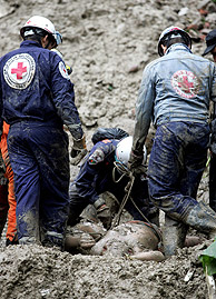 Miembros de Cruz Roja rescatando cadveres. (Foto: EFE)