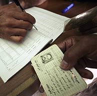 Un iraquí muestra su identificación para depositar su voto. (Foto: REUTERS)