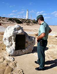 Un guardia civil observa la placa conmemorativa de la batalla que hay junto al Faro de Trafalgar. (Foto: EFE)