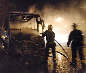 Los bomberos tratan de apagar un autobs incendiado en Porte de la Villette, cerca de Pars. (Foto: AFP)