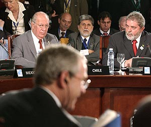 Bush, de espaldas, Lagos y Lula da Silva, durante la última reunión de la Cumbre. (Foto: AP)