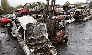 Un obrero retira los coches quemados durante los disturbios en Pars. (Foto: AFP)