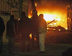 Vecinos de Toulouse charlan con un polica frente a un coche ardiendo. (Foto: REUTERS)