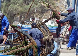 Pescadores de la almadraba de Zahara de los Atunes estiban en el puerto de Barbate las anclas que usan para fijar el laberinto de redes. (Foto: ELMUNDO)