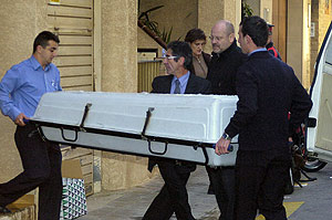 Los empleados de la funeraria sacan el cuerpo de la mujer del apartamento de Rosas. (Foto: EFE)