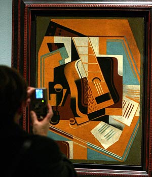 Un visitante del MNAC toma una foto de la obra de Juan Gris, "La guitarra" de 1918. (Foto: EFE)