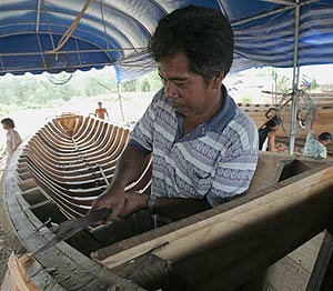 Un pescador tailands intenta reparar su barca. (Foto: AFP)