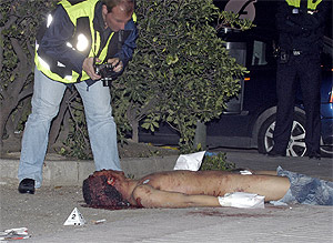 Un polica examina el cadver del dominicano asesinado en noviembre. (Toledo)
