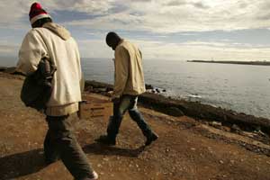 Dos inmigrantes pasean por la costa. (Foto: EFE)