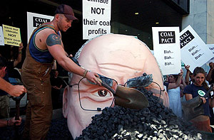 Un activista apila carbn sobre una efigie del primer ministro australiano, John Howard. (Foto: EFE)