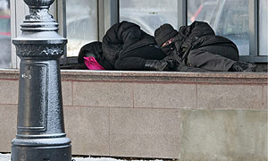 Dos mendigos, en la salida de aire caliente de un edificio en Moscú. (Foto: EFE)