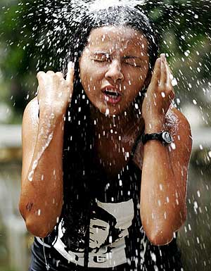 Una participante del Foro se refresca en una de las duchas del recinto. (Foto: REUTERS)