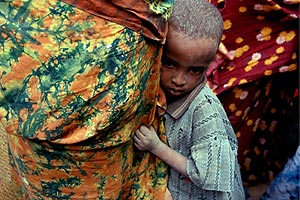 Un nio se agarra a las faldas de su madre en un centro de alimentacin en Kenia. (Foto: EFE)