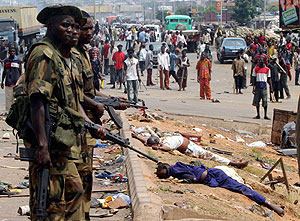 Dos policas, junto a varios cadveres en Onitsha. (Foto: REUTERS)
