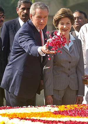 Bush, junto a su mujer, Laura, homenajea con flores a Mahatma Gandhi. (Foto: AP)