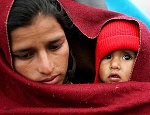 Una mujer, superviviente del terremoto, protege a su hijo con una manta. (Foto: REUTERS)