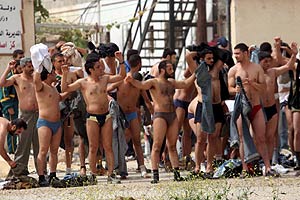 Palestinos semi desnudos y con los brazos levantados durante la operacin israel. (EFE)