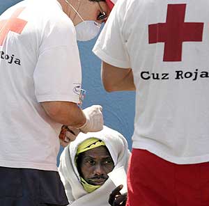 Un subsahariano ayudado por miembros de la Cruz Roja. (Foto: EFE)