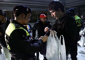 Un policía revisa las bolsas de un joven que pasaba por la zona del Faro de Moncloa. (Foto: EFE) Ver rectificación