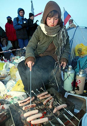 Miembros de la oposicin preparan la comida el jueves en el campamento montado en la plaza principal de Minsk. (Foto: EFE)