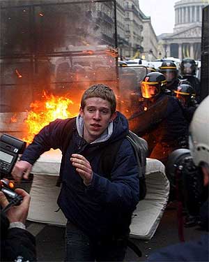 Un joven corre delante de la Polica en una manifestacin contra el CPE. (Foto: EFE)