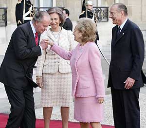 El Rey Juan Carlos besa la mano de Bernadette Chirac, en presencia de La Reina Sofía y del presidente galo. (Foto: AFP)
