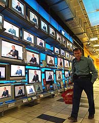 Un hombre pasa ante varios televisores durante el debate entre Berlusconi y Prodi. (Foto: AP)