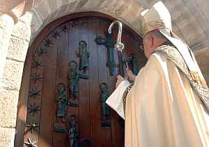 El obispo de Santander, Jos Villaplana, da los tres golpes de rigor que abren la Puerta del Perdn del monasterio. (Foto: EFE)