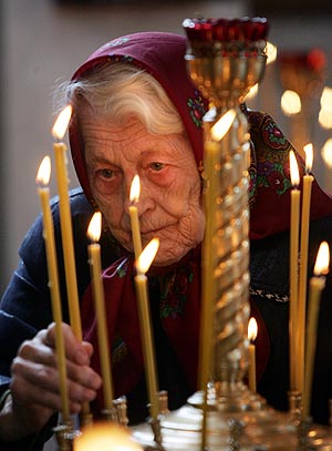 Una familiar de una de las víctimas enciende velas en su recuerdo. (Foto: AFP)