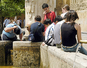 Un grupo de chicos se refresca en la fuente del Patio de la Mezquita de Crdoba para aliviarse del calor. (Foto: EFE)