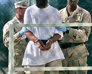Dos guardias trasladan a un preso en la base de Guantnamo. (Foto: AP)