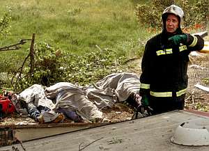 Un bombero, junto a los cuerpos de tres fallecidos. (Foto: EFE)