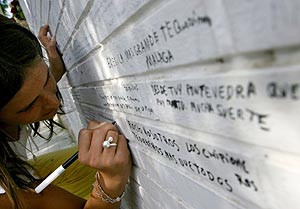 Una joven escribe un mensaje a la cantante en los muros de su casa en Chipiona. (Foto: AFP)