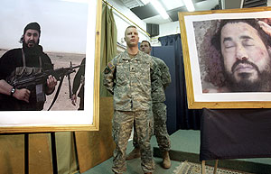 Dos soldados de EEUU entre fotos de Al Zarqaui y su cadáver. (Foto: AFP)