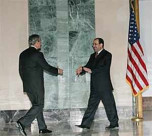 Bush y Maliki se saludan en la embajada de EEUU en Bagdad durante la visita sorpresa del estadounidense. (Foto: AP)