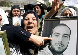 Palestinos se manifiestan en Hebrn con fotos de sus familiares encarcelados en prisiones israeles. (Foto: AFP)
