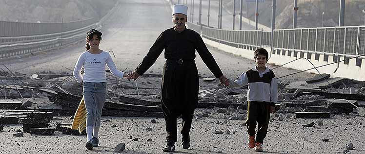 Un hombre cruza a pie con dos nios la carretera Beirut-Damasco, bombardeada por Israel. (Foto: AFP)