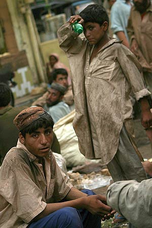 Nios pakistanes esperan a que les regalen los restos de comida de una cafetera. (Foto: EFE)