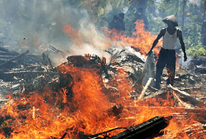 Soldados queman los restos de las viviendas derribadas por el 'tsunami' en Java. (Foto: AP)