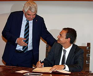 Zapatero, escribiendo la dedicatoria en el libro de honor ante Maragall. (Foto: AFP)