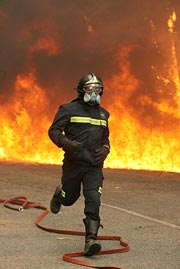 Un bombero huye del fuego. (Foto: EFE)
