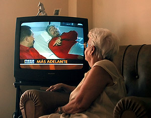 Una mujer mira en su televisin el primer vdeo de Castro tras ser operado. (Foto: AFP)