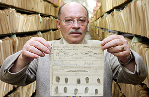 Un hombre muestra el documento que prueba que Grass fue miembro de las SS. (Foto: EFE)