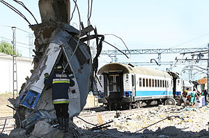 Trozo del tren accidentado en un pilar de una pasarela. (Foto: EFE)