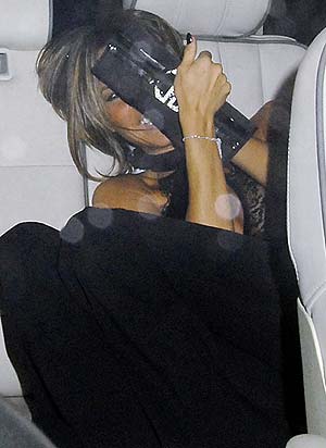 Victoria Beckham oculta su rostro tras un bolso, mientras se muere de risa en el coche. (Foto: Enfoque)
