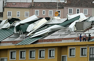 Operarios en el tejado de una vivienda arrancado por el viento en Corcubin. (Foto: EFE)